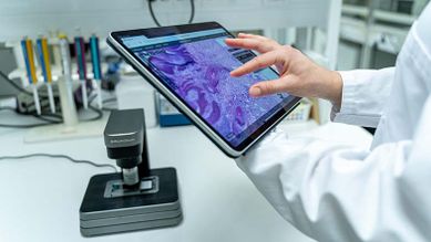 Grundium Ocus pöydällä ja patologi tutkii iPadilla näytteitä